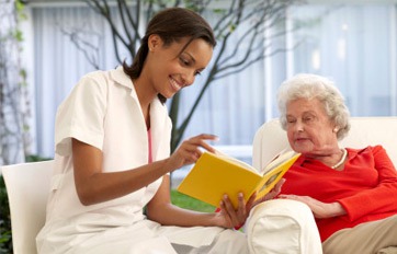 Enfermera lee para adulto mayor
